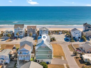 A coastal residential area with houses, a beach, and a clear view of the ocean. - Shore Sounds Fun by Topsail Realty (Holly Ridge)