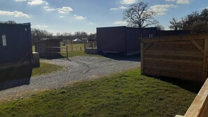 A fenced outdoor area with multiple buildings, a gravel path, and a grassy field. - Calm and nature 40kms from Mt St Michel Chausey near Granville and beaches (Longueville)