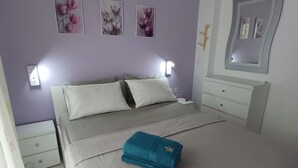 A bedroom with a bed, nightstands, a dresser, and wall-mounted lights. - 100 meters from the blue flag awarded Mesi Beach. (Paralia Mesis)