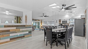A modern kitchen with a central island, built-in appliances, and a dining area with a large table and chairs.
