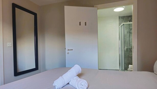 Una habitación de hotel con una cama, una puerta y una zona de ducha.