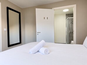 Une chambre d’hôtel avec un lit, une porte et un espace douche.