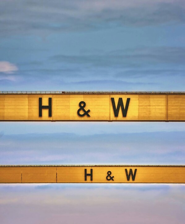 A sign with the letters "H & W" on a yellow background.