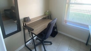 A small office space with a desk, chair, and a window with blinds. - Pet Friendly Apartment In Arena District with Parking (Detroit)