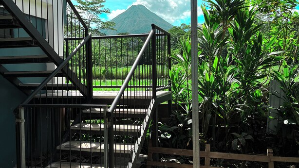 Una escalera conduce a un balcón con vistas a la montaña.