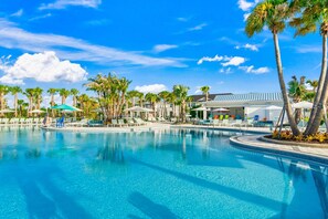 A swimming pool with lounge chairs and palm trees. - 1287 Blue Paradise Way (Clermont)