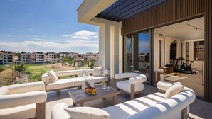 A modern outdoor living area with white furniture, a dining table with fruit, and a view of the surrounding neighborhood. - Pet friendly home in Petrcane with sauna (Petrcane)
