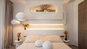 A modern bedroom with a large bed, bedside lamps, and a wall-mounted light fixture. - Pet friendly home in Petrcane with sauna (Petrcane)