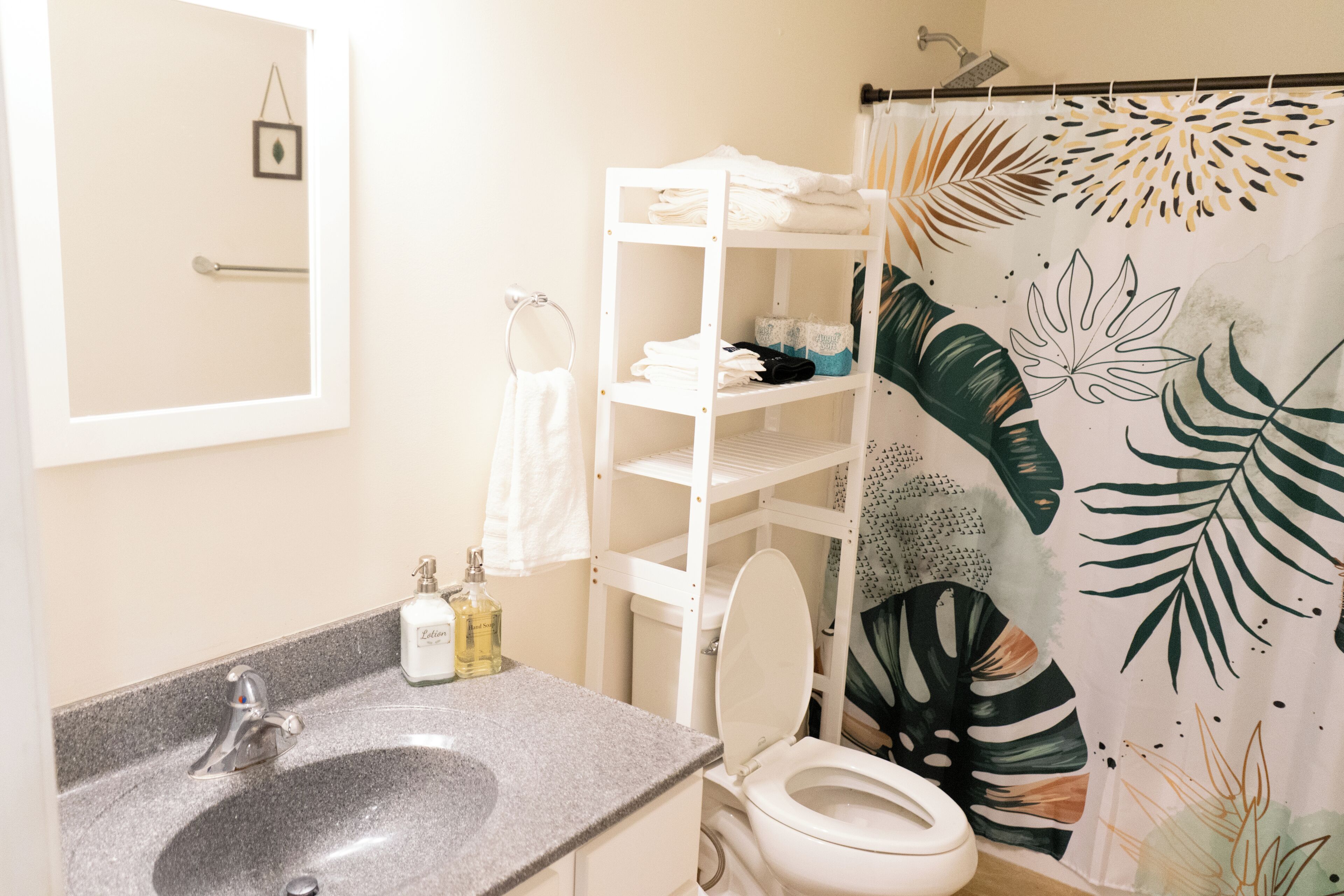 A bathroom with a sink, toilet, and shelves with towels.