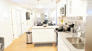 Una cocina moderna con armarios blancos, electrodomésticos de acero inoxidable y una isla central.