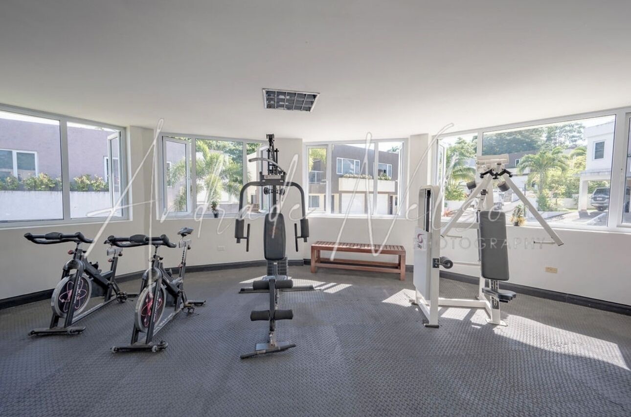 Una palestra con cyclette, tapis roulant e macchinari per l'allenamento con i pesi.