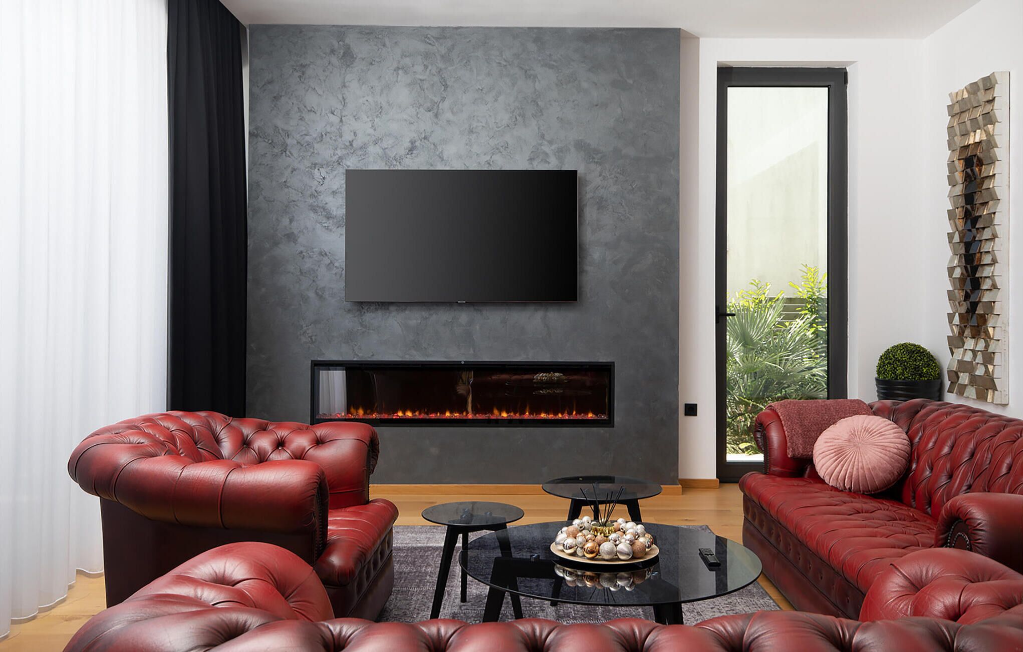 Ein modernes Wohnzimmer mit Kamin, Ledersofas und einem flachbildfernseher an der Wand.