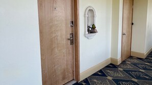 Ein Flur mit Holztüren, einem kleinen Dekobrett und einem Teppich mit Muster.