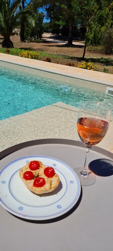 Stone farmhouse surrounded by greenery with shared pool