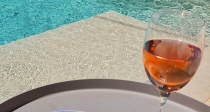 Stone farmhouse surrounded by greenery with shared pool