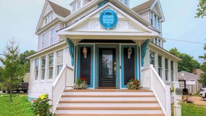 A two-story house with a front porch, a blue door, and a sign that reads "Huddy House". - Huddy House Bed & Breakfast (Toms River)