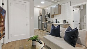 Une cuisine moderne avec des meubles blancs, un four à micro-ondes et une cuisinière.