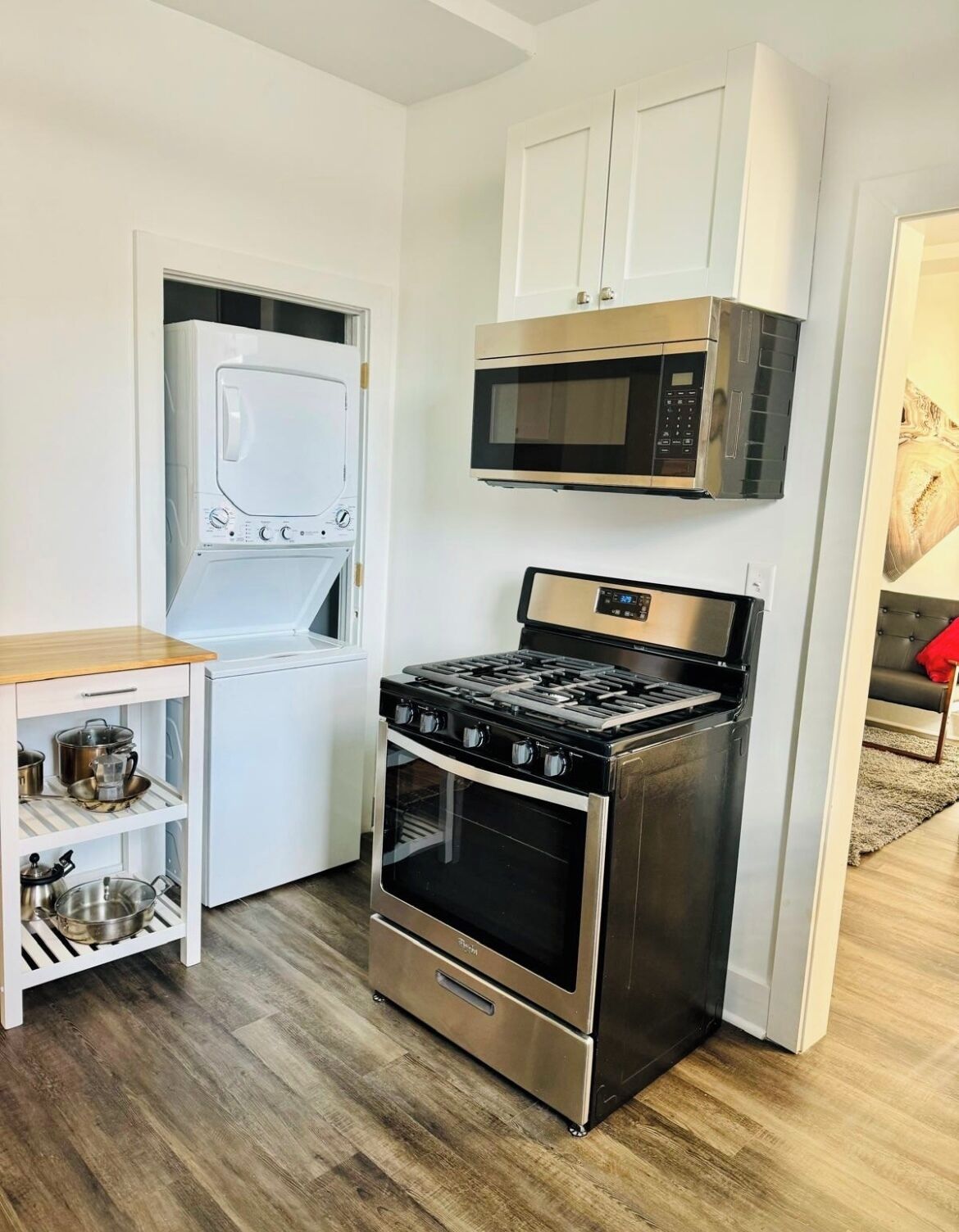A compact kitchen with a built-in washer, a microwave, and a gas stove.