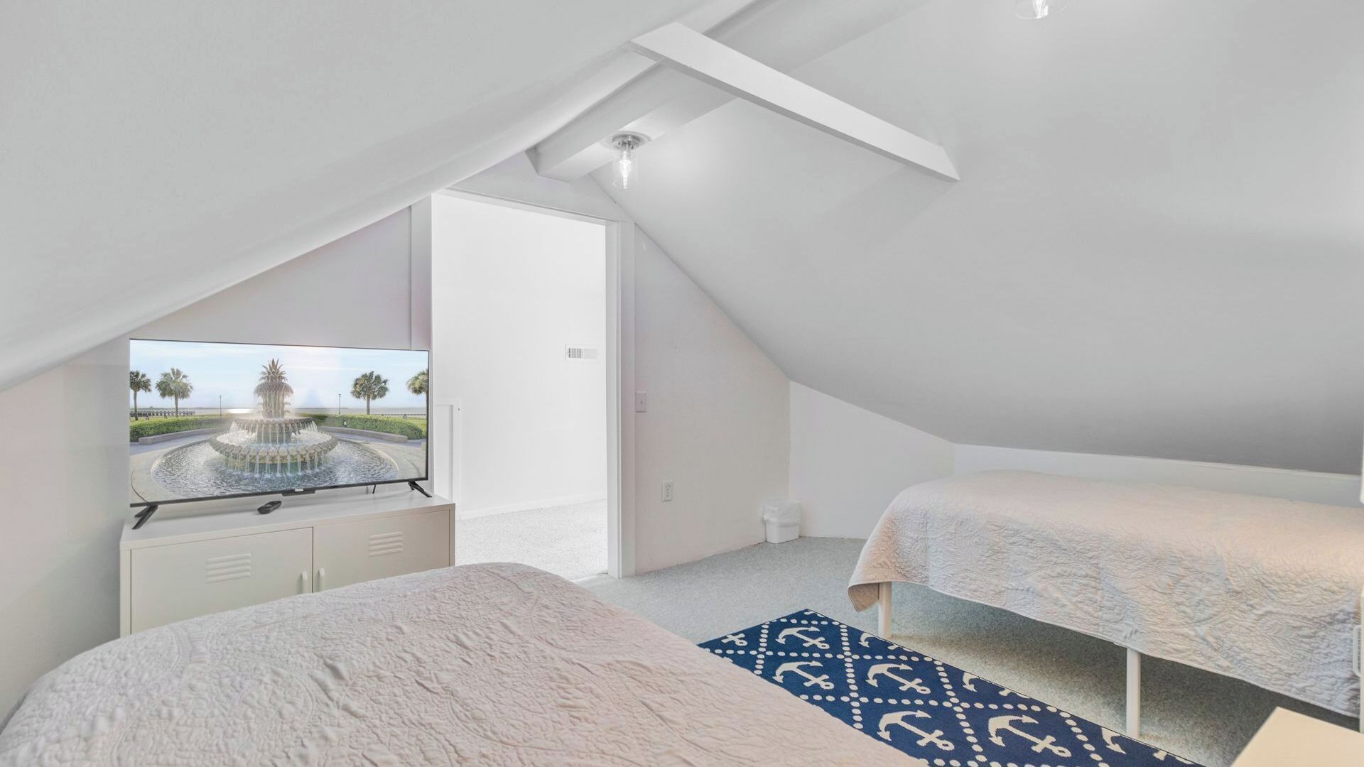 A bedroom with a bed, a TV, and a view of a fountain.
