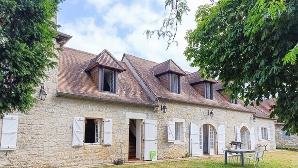 A stone building with multiple windows and a tiled roof. - Gîtes de France® - Le Clo (SAINT MICHEL DE BANNIERES)