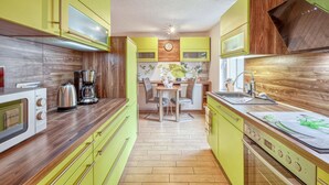A compact kitchen with a wooden countertop, a coffee maker, a microwave, and a sink.