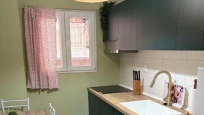 Una cocina compacta con lavadora, un lavamanos y una zona de comedor con mesa y sillas.