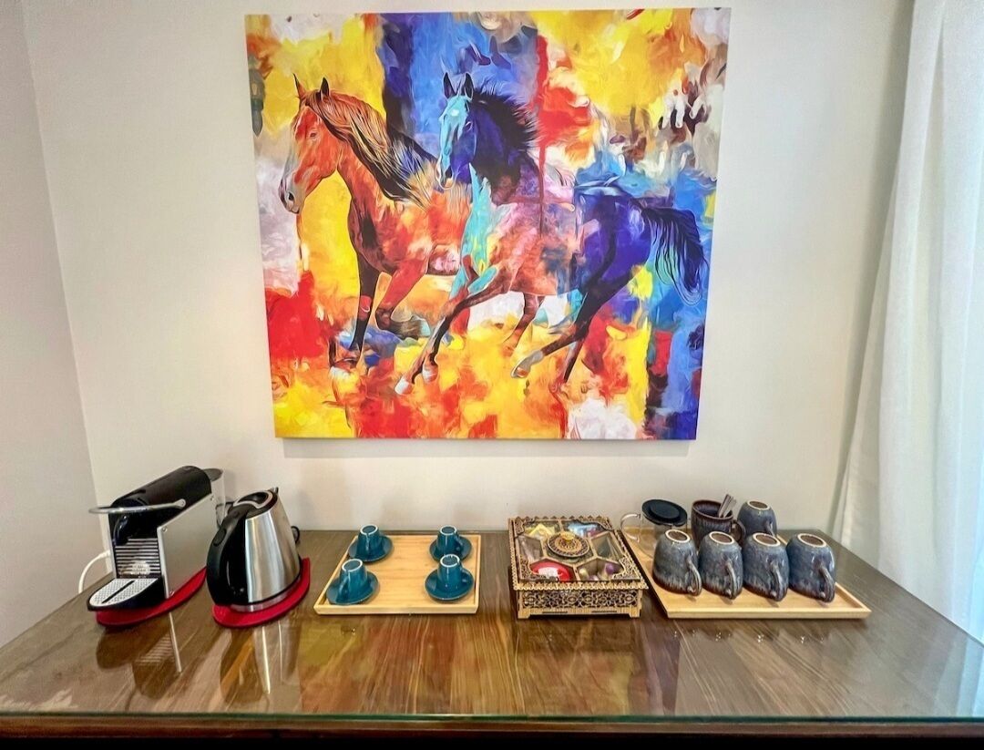 Ein Tisch mit Kaffeemaschine, Teekanne, Tassen und einer dekorativen Schachtel.