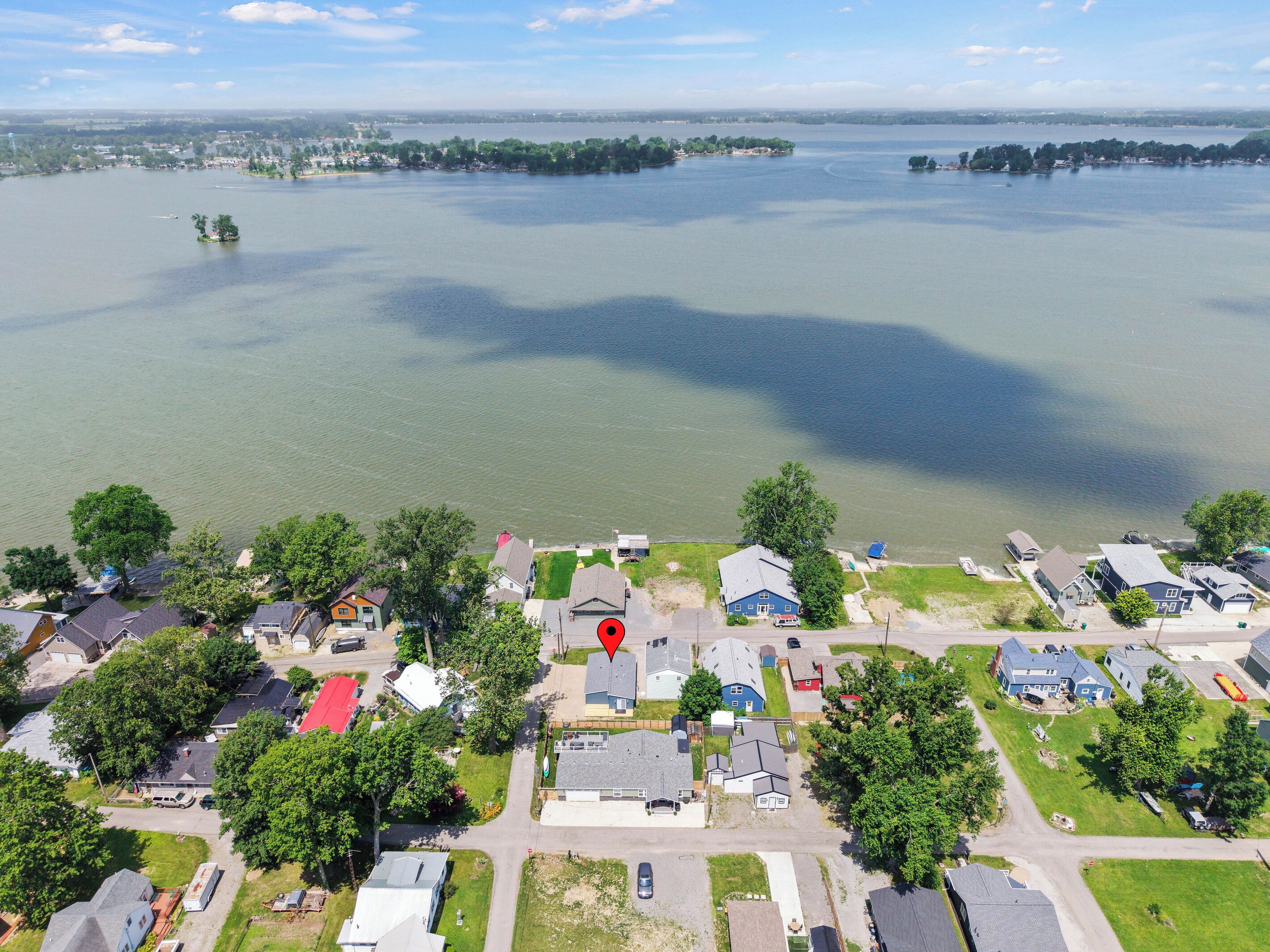 A residential area with houses, a lake, and a red marker indicating a specific location.