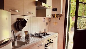 Una cocina moderna con estufa a gas, horno y pileta de acero inoxidable.
