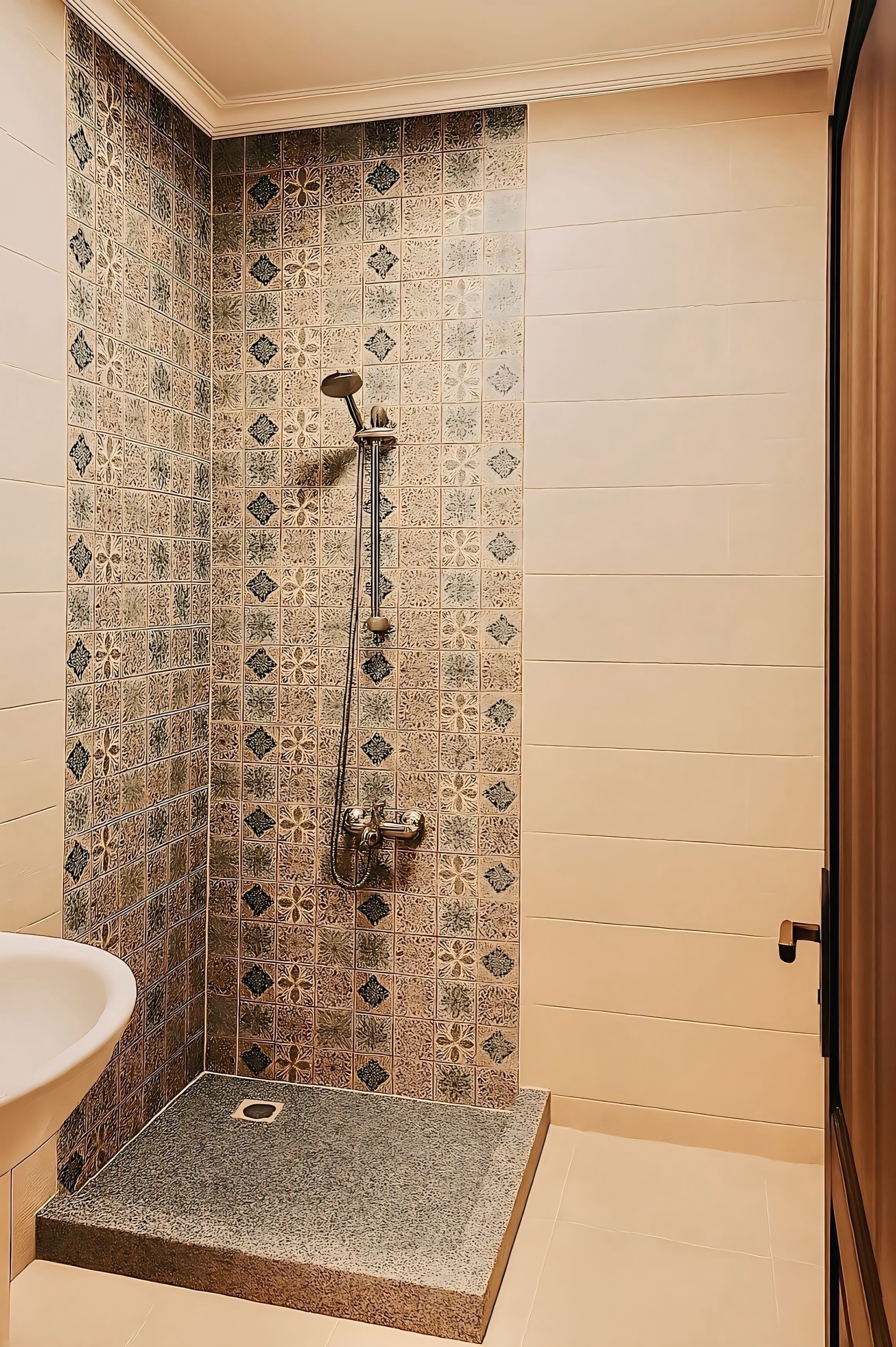 Un espace douche avec un mur carrelé et un pommeau de douche.