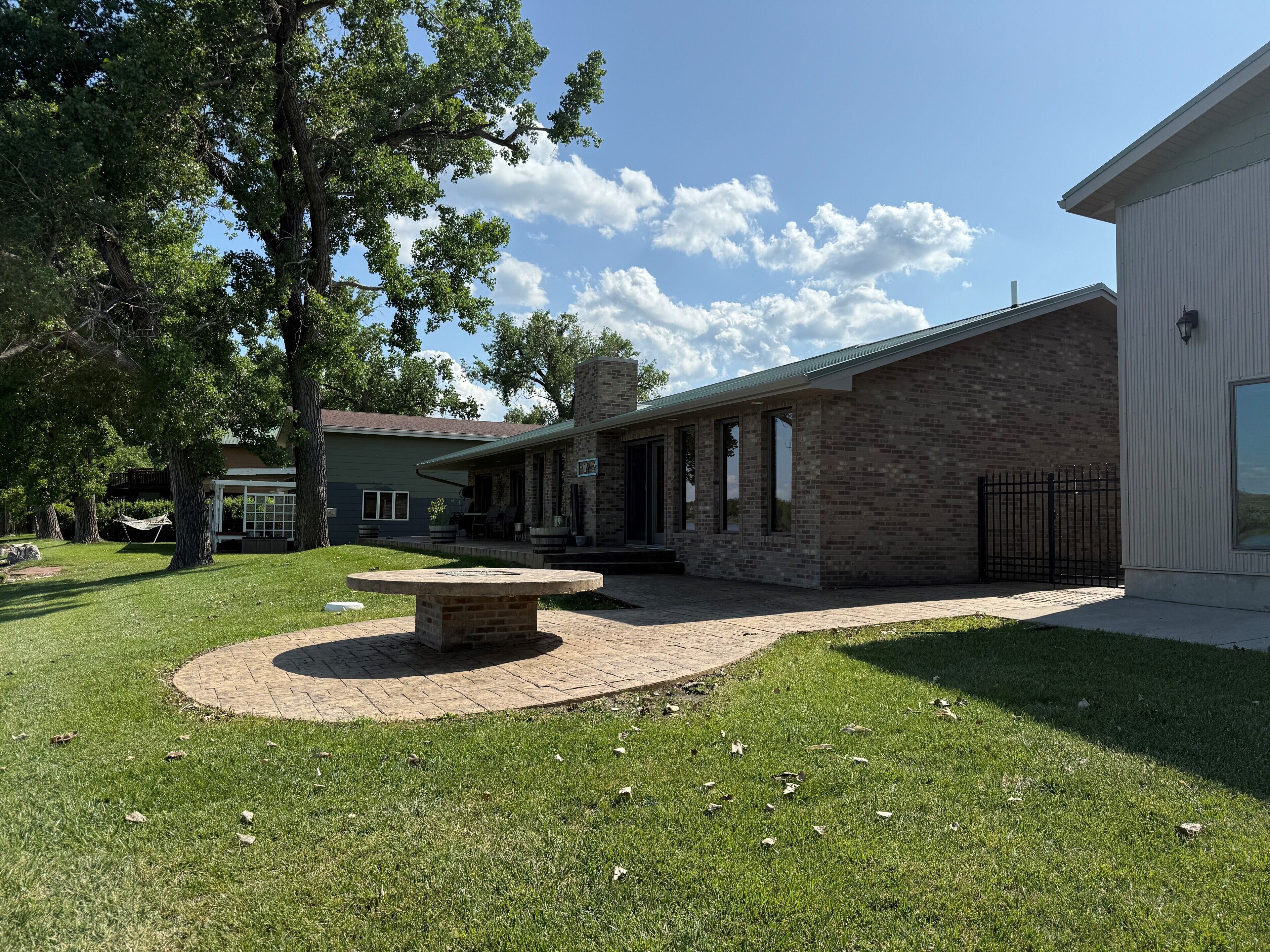 A residential property with a patio, outdoor seating, and a brick fireplace.