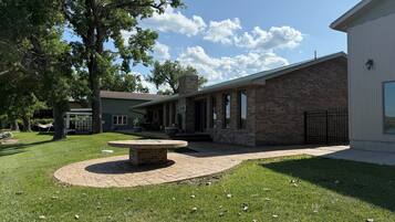 A residential property with a patio, outdoor seating, and a brick fireplace.