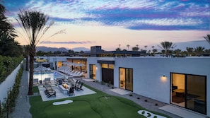 A modern resort with a swimming pool, sun loungers, and a view of mountains. - Sleeps 32 2 Villas, Pool, Putting Green+bocce Polo Villas Amara by Avantstay (La Quinta)
