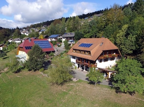 A residential area with houses, some with solar panels, surrounded by trees and hills. - Apartment 'Gartenblick' with Shared Terrace, Shared Garden and Wi-Fi (Schramberg)
