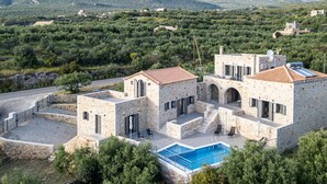 Une villa en pierre dotée d’une piscine, de nombreuses pièces et offrant une vue sur le paysage environnant.