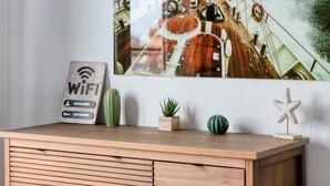 A wooden cabinet with a sign that reads "WiFi" and a cactus. - Le Léon Gambetta, appartement avec terrasse vue mer (Dieppe)