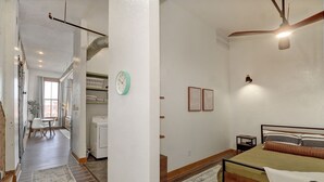 Un dormitorio con cama, mesita de noche y un reloj en la pared.