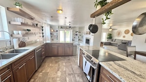 Una cocina moderna con armarios de madera, encimera de granito y horno empotrado.