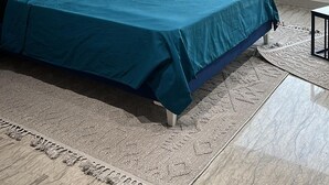 Una camera da letto moderna con un letto grande, vista sulla città e due stampe botaniche incorniciate al muro.