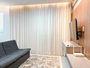 Apartamento superior, 1 cama Queen, sacada, vista para a cidade | Sala de estar
