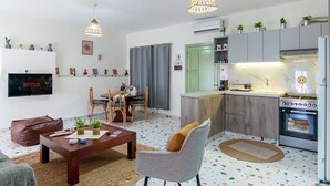 A compact living space with a dining area, kitchen, and a TV displaying 'NETFLIX'.