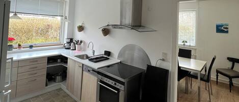 A modern kitchen with a built-in oven, a stainless steel range, and a black countertop.