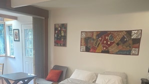 Une chambre à coucher avec un lit, une chaise, une table et une fenêtre.