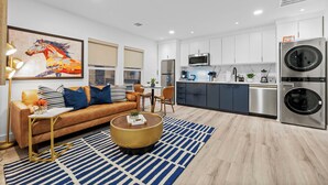 A modern apartment with a living room, kitchen, and dining area.