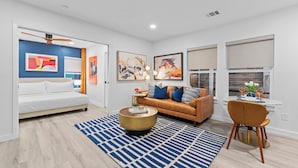 A modern living room with a sofa, coffee table, and dining area.