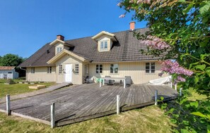 Ett tvåvåningshus med en träveranda, en ytterdörr och en liten veranda.