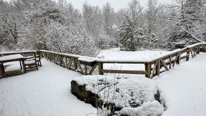 A snow-covered wooden deck with benches, surrounded by snow-laden trees. - Awesome home in Sturkö with sauna (Sturkö)