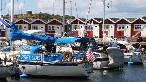 En lystbådehavn med fortøjede både, heriblandt en båd ved navn 'PRELUDE' med det amerikanske flag.