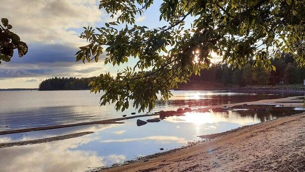 A calm lake with a sandy shore, surrounded by trees and a distant shoreline. - Amazing home in Kristinehamn with WiFi (Kristinehamn)