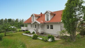 A two-story house with a red-tiled roof, white siding, and a front porch. - Amazing home in Kristinehamn with WiFi (Kristinehamn)